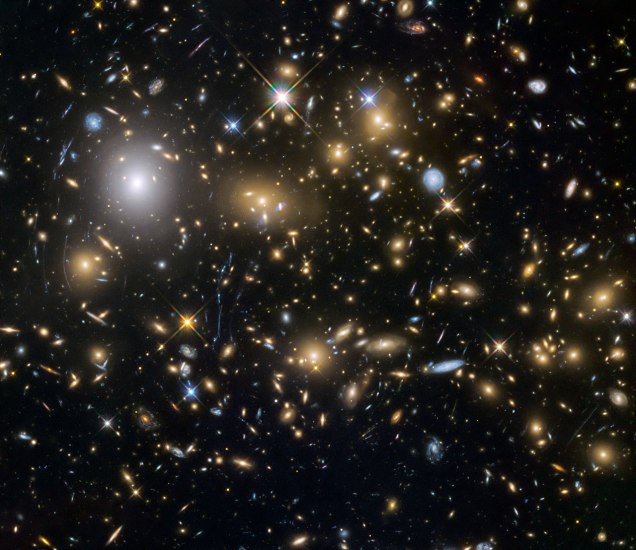 Photo: Hubble Space Telescope image of distant galaxy cluster and gravitational lensing. Credit: NASA/ESA