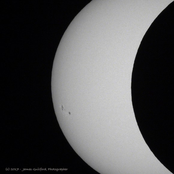 Photo: Edge of lunar silhouette shows mountains on Moon. Photo by James Guilford.