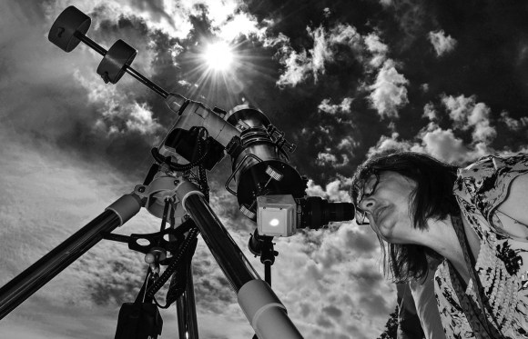 Photo: Woman watches eclipse through specially-equipped telescope. Credit: Dave Dreimiller